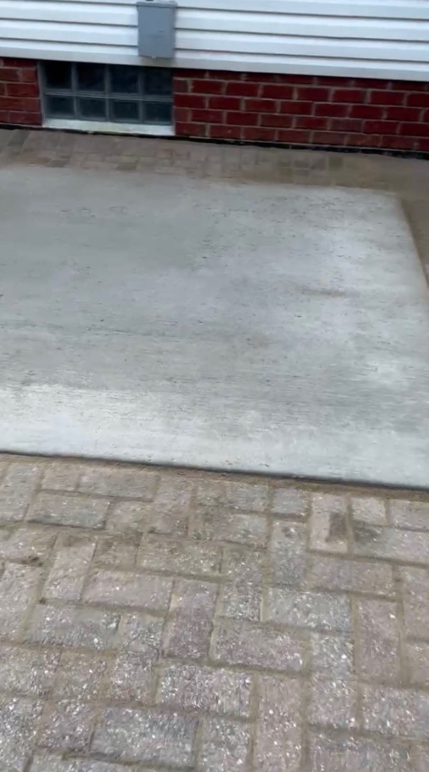 Concrete pad next to brick wall